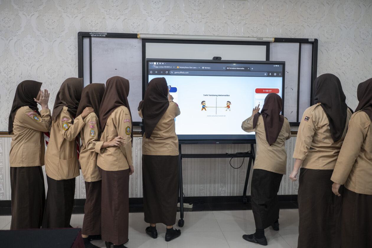 Siswa sekolah menengah kejuruan menggunakan papan interaktif digital untuk pembelajaran matematika di kelas
